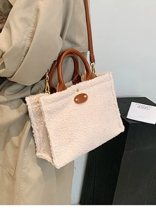 Tragebeispiel einer cremeweißen Lammfell-Tote-Bag mit braunen Ledergriffen für Damen