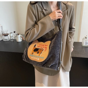 Detail of dark grey corduroy tote bag featuring a cute yellow cat patch and spacious interior