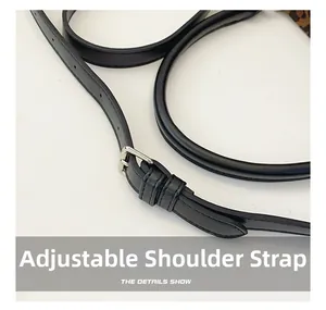 Détail de la bandoulière réglable en cuir noir avec une boucle en métal argenté