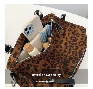 Capacité interne du sac fourre-tout léopard montrant le rangement du téléphone et du maquillage