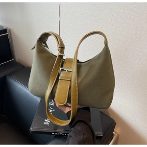 Detail of olive green suede crescent bag with leather strap and silver buckle accent
