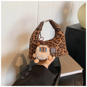 Detailed view of leopard print crossbody bag with cute white plush sheep charm