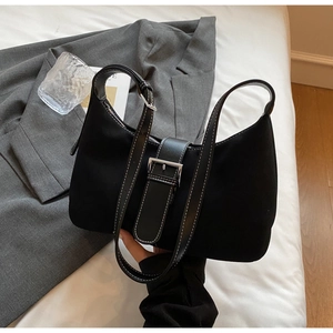 Detail of black hobo bag showing contrast stitching and silver buckle adjustment