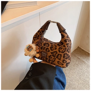 Detail of leopard print hobo bag with leather handle and white sheep plush charm