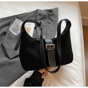 Detail of black hobo bag with contrast white stitching and silver buckle accent