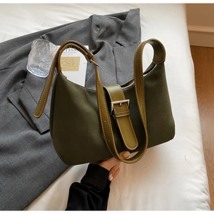 Detail of olive green suede underarm bag with light green leather strap and silver buckle