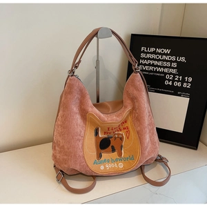 Detail of pink corduroy tote bag featuring large cat patch and leather strap texture