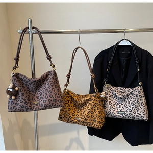 Detailed shot of leopard print tote bags in three colors featuring knotted shoulder straps