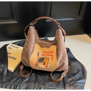 Detail of a brown corduroy tote bag featuring a cute cat embroidery and leather handles