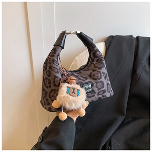 Detail of leopard print hobo bag with leather handle and cute lamb plush pendant charm