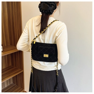 Quilted velvet shoulder bag with gold chain strap shown on model's side view
