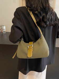 Olive green hobo underarm bag with decorative leather buckle and white stitching detail