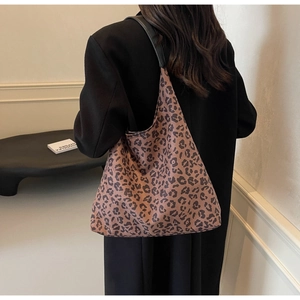 Close-up of a large leopard print tote bag with a wide black strap and canvas texture