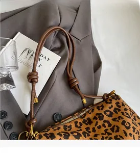 Detail of leopard print tote bag with knotted shoulder straps and golden metal tips
