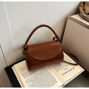 Detail view of glossy brown vintage handbag showing CLEA RCK logo and handle texture