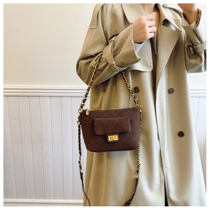 Detailed view of brown quilted crossbody bag with gold chain strap and square metal buckle