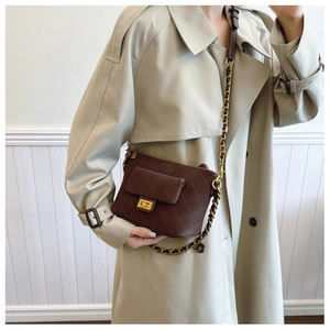 Detail of a brown quilted leather crossbody bag featuring a golden metal turn-lock closure