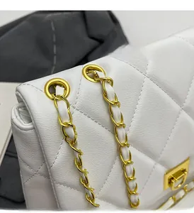 Detail of white quilted leather bag with gold chain strap and metallic lock closure