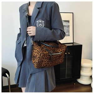 Sac fourre-tout léopard porté avec un blazer gris et une jupe plissée moderne