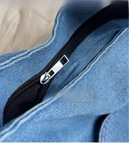 Detailed macro view of the smooth silver metal zipper on durable blue denim tote bag