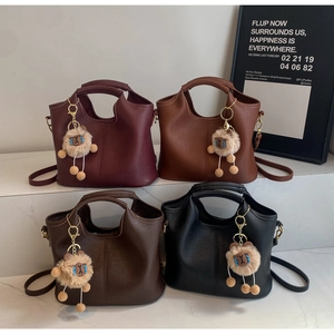 Minimalist tote bags in four colors with plush charms and adjustable straps displayed together