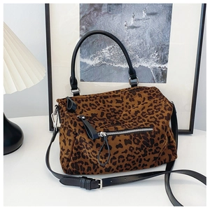 Détail d'un sac cabas léopard avec poignées en cuir noir et fermeture éclair argentée
