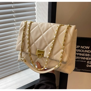 Detail der cremefarbenen Stepptasche mit goldener Kette und edlem Metallverschluss
