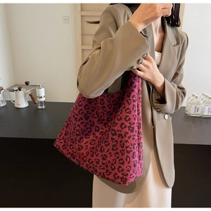 Close-up of fuchsia leopard print tote bag styled with a khaki blazer for workwear