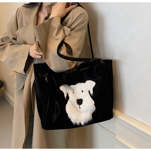 Detailed view of black tote bag featuring a 3D plush dog patch on beige coat