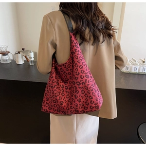 Leopard print tote bag shown on shoulder in a modern cafe setting with brown blazer