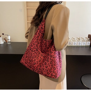 Detail of large leopard print tote bag in dark red fabric with black shoulder straps