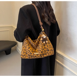 Detail of leopard print hobo bag with leather knotted strap and plush charm accent
