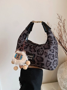 Chic leopard print plush handbag with black leather handle and cute animal charm accessory