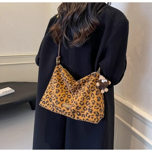 Leopard print tote bag detail with brand leather patch and cute brown monkey keychain