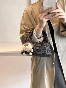 Leopard print handbag with plush lamb pendant and black leather straps in mirrorselfie