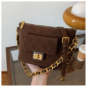 Close-up of brown suede crossbody bag with quilted stitching and gold chain strap