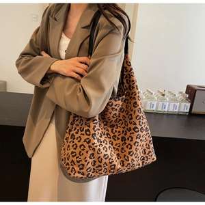 Macro detail of large leopard print tote bag with black strap and canvas texture