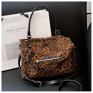 Gros plan sur le sac fourre-tout léopard avec fermeture éclair argentée et anse en cuir noir