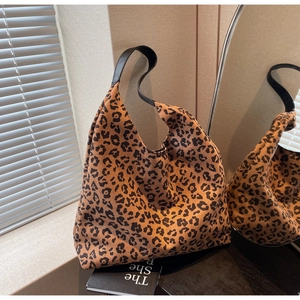 Macro shot of large leopard print hobo bag showing pattern detail and black strap