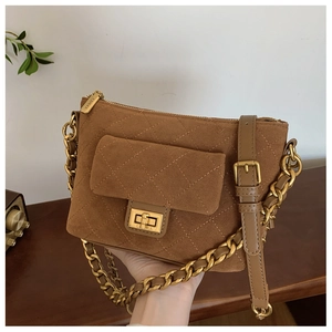 Detail of brown suede quilted crossbody bag with gold twist lock and metal hardware