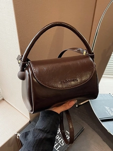 Retro dark brown glossy leather mini crossbody bag with top handle and curved flap design