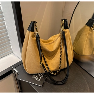 Detail of vintage matte yellow suede tote bag with chain strap and black leather trim