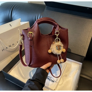 Detail of burgundy vintage tote bag with sheep charm and removable shoulder strap