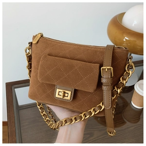Detail of brown suede quilted crossbody bag with gold chain strap and turn-lock