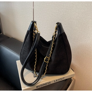 Detail of black suede hobo bag with vintage gold hardware and adjustable leather strap