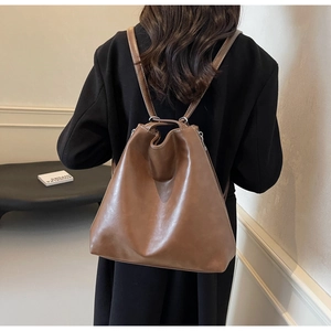Detail of vintage caramel leather backpack with bucket-style drawstring closure