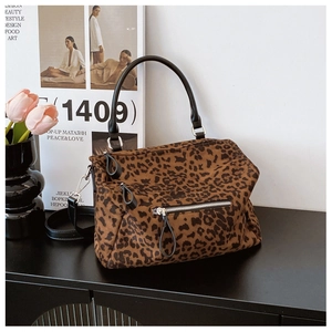 Sac fourre-tout chic à imprimé léopard avec anses noires sur un bureau minimaliste