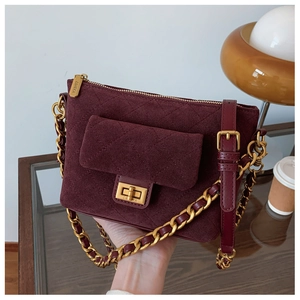 Close-up of wine red quilted handbag featuring vintage texture and gold clasp detail
