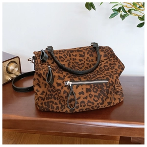 Détail du sac cabas léopard avec poignée en cuir noir et fermeture éclair argentée