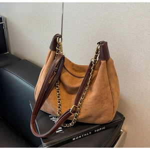 Detailed view of brown matte suede shoulder bag with dual leather and gold chain straps